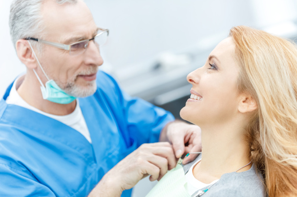 tandarts met patiënt in tandheelkundige kliniek - Foto, afbeelding