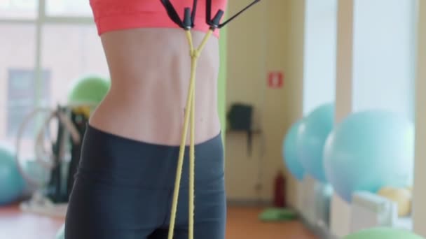 Nice girl posing with expander in fitness room - Metraje, vídeo