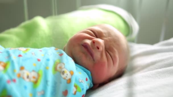 Neugeborener Junge schlafend in ihrem Bett in der Geburtsklinik. Weinen - Filmmaterial, Video