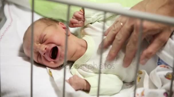 生まれたばかりの赤ちゃん女の子彼女のお父さんを彼女のクローズ アップ ショットを慰めようとしながら泣いています。 - 映像、動画