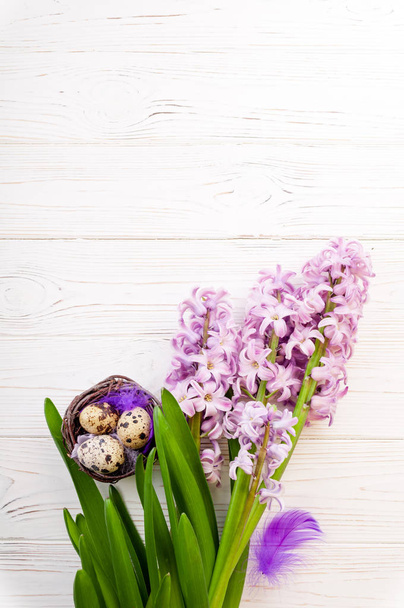 Paskalya arka plan. Sümbül bahar çiçekleri ve Beyaz ahşap zemin üzerinde yumurta yuva - Fotoğraf, Görsel
