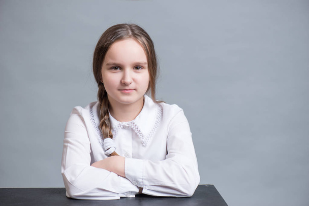 Happy schoolgirl sitting at a desk - Foto, Imagem