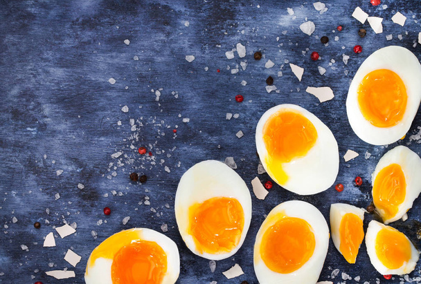 Hardgekookte eieren, gesneden in helften op houten tafel  - Foto, afbeelding