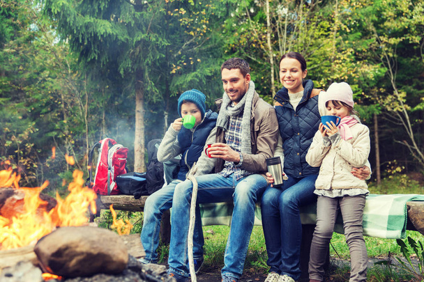 happy family sitting on bench at camp fire - Photo, image
