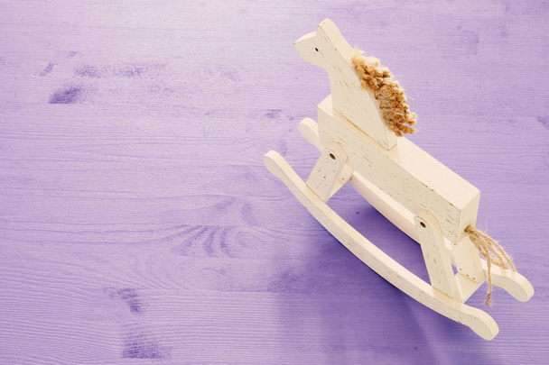 top view angle of vintage rocking horse on wooden purple background - Fotoğraf, Görsel