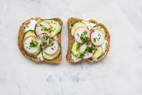 Sandwich with cucumber and radish lie on a light background - 写真・画像