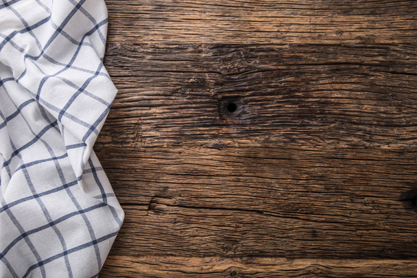 Top view of checkered tablecloth or napkin on empty wooden table - Foto, imagen