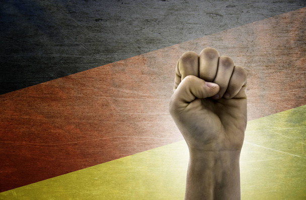 Mão cerrada no punho contra o fundo da bandeira Alemanha
 - Foto, Imagem