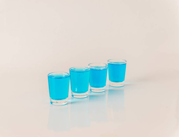 vier Gläser blauen Kamikaze, glamouröses Getränk, Mixgetränk gießen - Foto, Bild