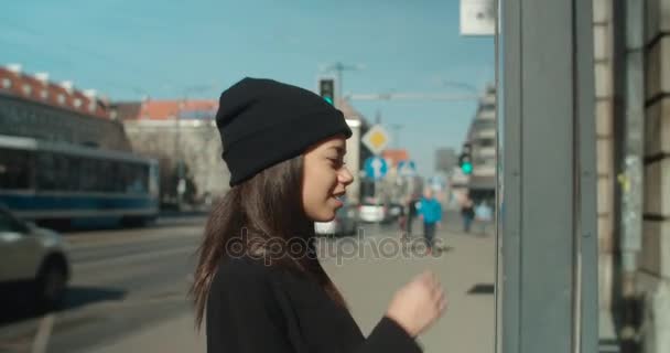 Afro American woman at bus stop reading timetable. - Video, Çekim