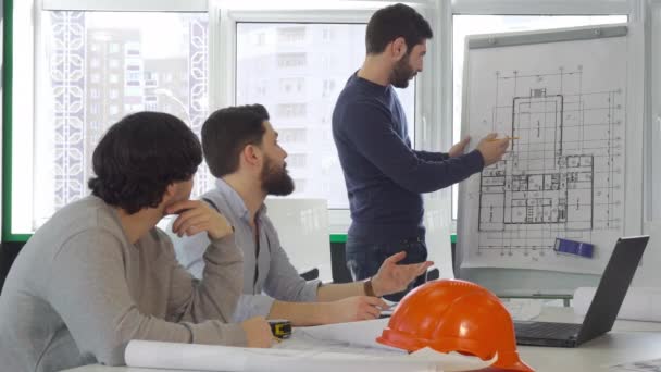 Команда архитекторов рассматривает проект здания
 - Кадры, видео