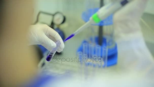 Fecho dos tubos de ensaio. Equipamento médico. Imagens de perto de um cientista usando uma micro pipeta em um laboratório. Técnico de laboratório injetando líquido em uma placa de microtitulação. Tubos de ensaio. Pequena profundidade de
 - Filmagem, Vídeo