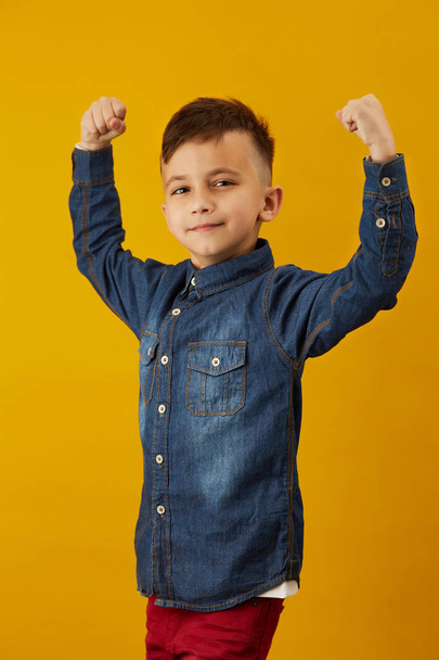 Beauty smiling sport child boy showing his biceps - Valokuva, kuva