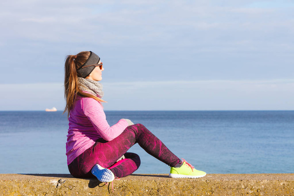 Woman resting after doing sports outdoors on cold day - Foto, Imagem