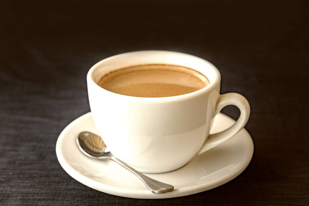Taza blanca de café sobre fondo azul oscuro
 - Foto, imagen