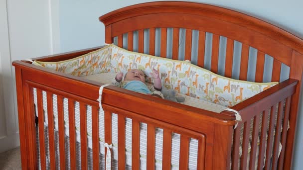 A toddler watches his newborn brother in his crib - Video