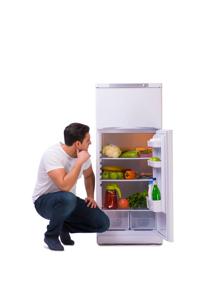 Man next to fridge full of food - 写真・画像