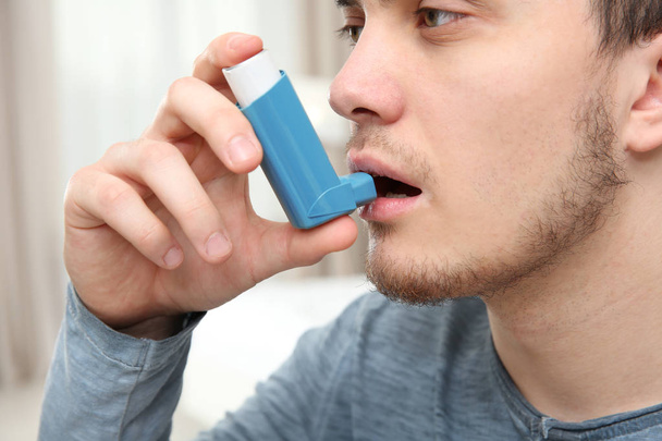 Young man using inhaler - Фото, изображение