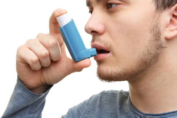 Young man using inhaler - 写真・画像
