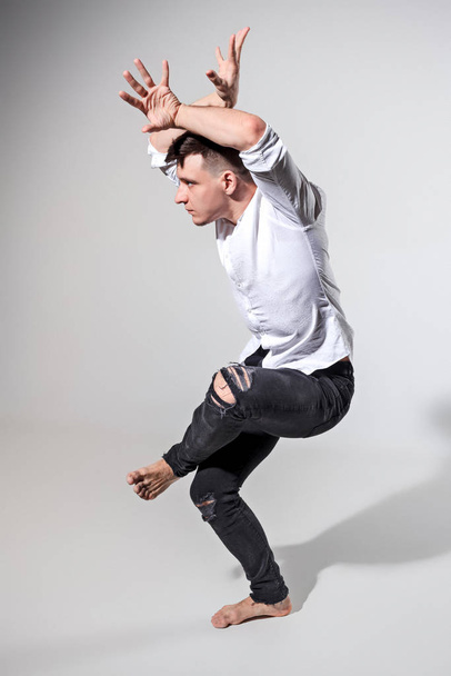 The young man dancing on gray - Foto, afbeelding