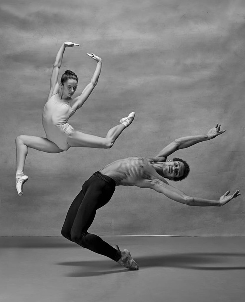 Couple of ballet dancers posing over gray background - Fotoğraf, Görsel