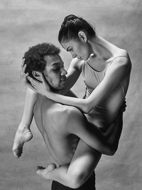 Couple of ballet dancers posing over gray background - Foto, immagini