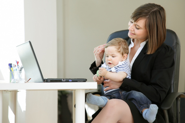 Lovely young working mother and her baby, in her Home Office, Little Break for Cuddling - Foto, Bild