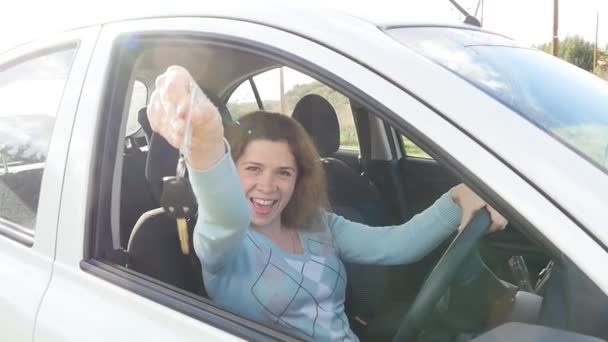 Młoda kobieta wyświetlone jest kluczem do nowego samochodu - Materiał filmowy, wideo