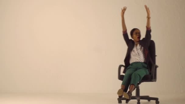 Happy black woman rides on office chair - Video