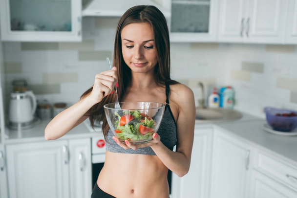 Fitness meisje eet verse salade - Foto, afbeelding