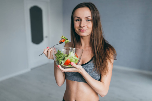 Фитнес-девушка ест салат
 - Фото, изображение