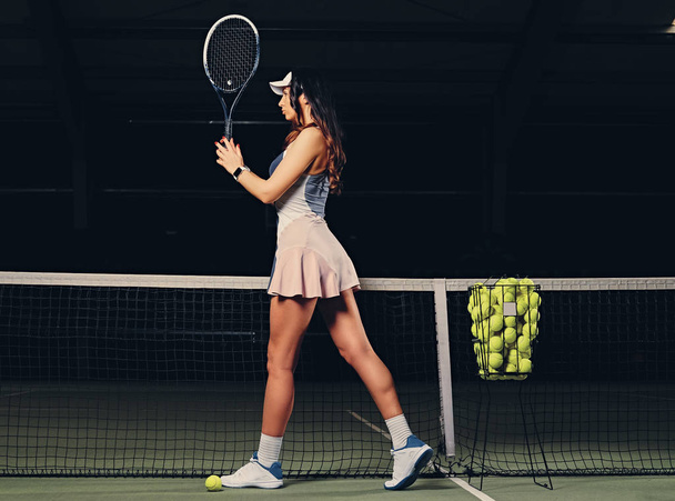 Жінка-тенісистка позує на корті
 - Фото, зображення
