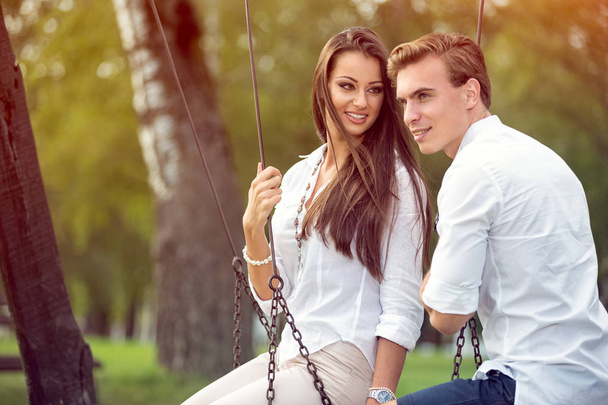 Couple in love on swings - Фото, зображення