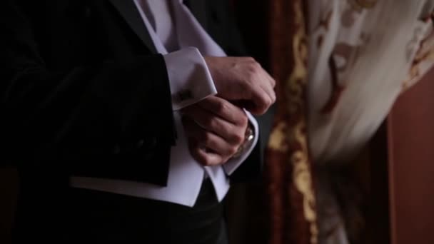 Ženich se drží za ruce na kravaty, svatební oblek. Detailní záběr ruky člověka jak nosí bílé košile a manžetové knoflíčky. Obchodní muž oprava černou kravatu na bílou košili. Ženicha na svatební den stanovení kravatu, vintage - Záběry, video