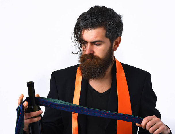 Brutal caucasian hipster with ties on shoulder holding bottle - Foto, immagini
