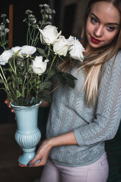 Florist at work: pretty young blond woman holds fashion modern bouquet of different flowers - Foto, imagen