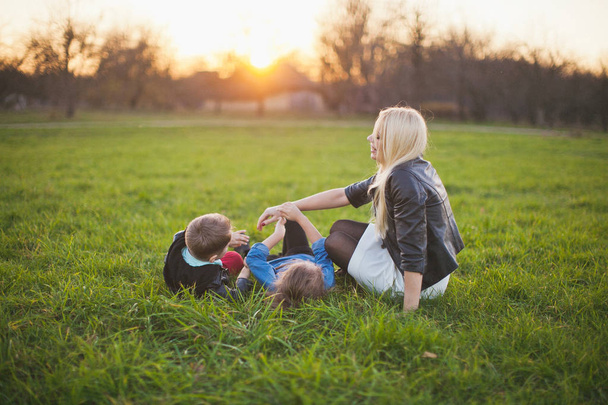 Mère avec deux enfants sur la pelouse
 - Photo, image