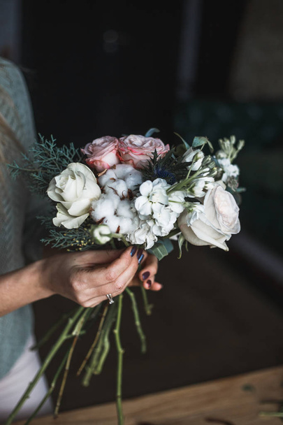 Florist at work: pretty young blond woman holds fashion modern bouquet of different flowers - Photo, Image