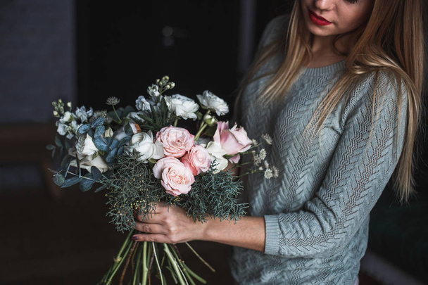 Florist at work: pretty young blond woman holds fashion modern bouquet of different flowers - Foto, immagini