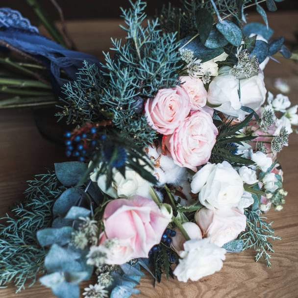 Florist workplace: flowers and accessories on a vintage wooden table. soft focus. Modern bouquet in a vase on a table, simple composition - 写真・画像