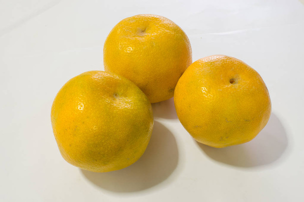 Whole and sliced orange fruits isolated on white. - Φωτογραφία, εικόνα