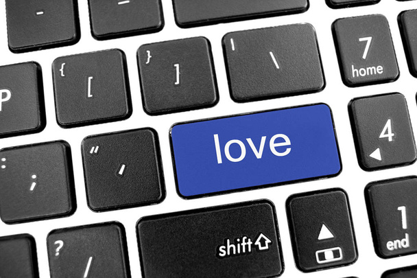 Clavier plat moderne noir d'un ordinateur portable avec bouton bleu : amour
 - Photo, image