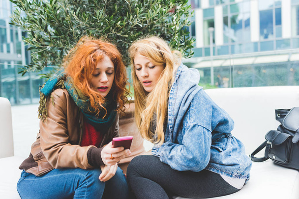 mulheres usando smartphone ao ar livre
  - Foto, Imagem