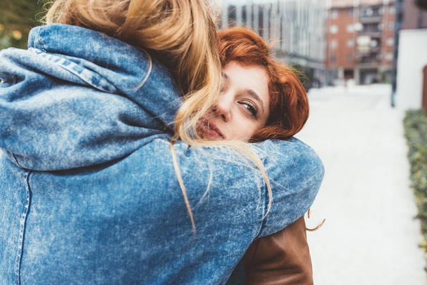 Freundinnen umarmen sich im Freien  - Foto, Bild
