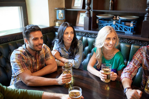 friends with beer watching football at bar or pub - Foto, Imagen