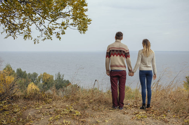 Heureux couple réfléchi debout sur une falaise près de la mer étreignant eac
 - Photo, image