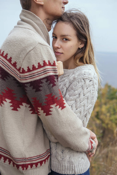 Happy thoughtful couple standing on a cliff near sea hugging eac - Photo, Image