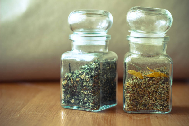 Dried spices or herbs picked in Spring and Summer in white decorative jars - 写真・画像
