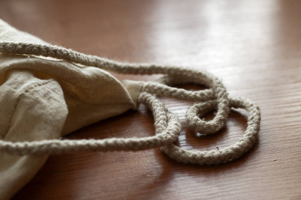 White cotton sack on wooden back ground close up - Fotó, kép