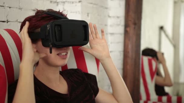 Młoda kobieta korzystająca z zestawu słuchawkowego wirtualnej rzeczywistości - Materiał filmowy, wideo
